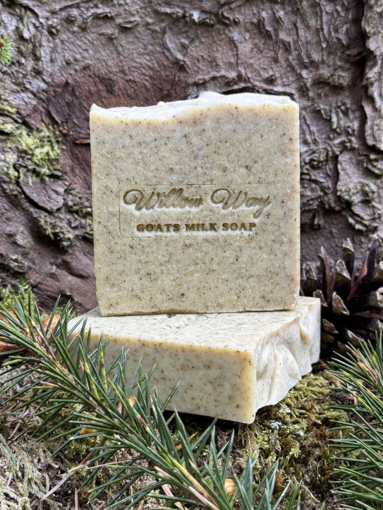 A bar of goats milk soap against a tree