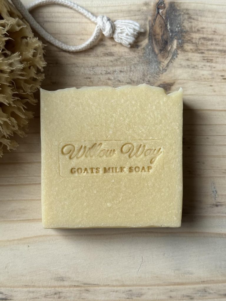 A bar of goats milk soap on a wooden board